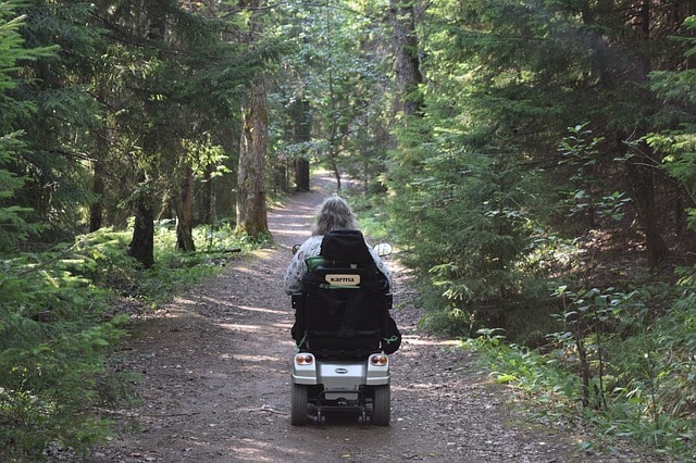 Senior woman mobility scooter in woods, comfort plus name-brand and pre-owned mobility scooters Langley and Surrey